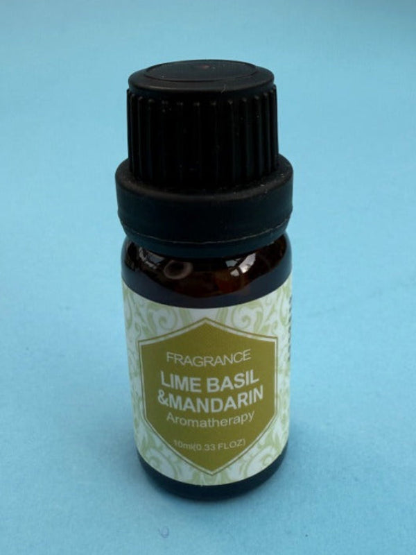 Bottle of Lime Basil & Mandarin fragrance oil on a light blue background