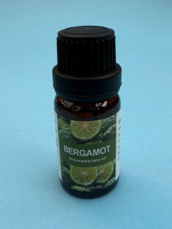 Bottle of bergamot essential oil on a light blue background